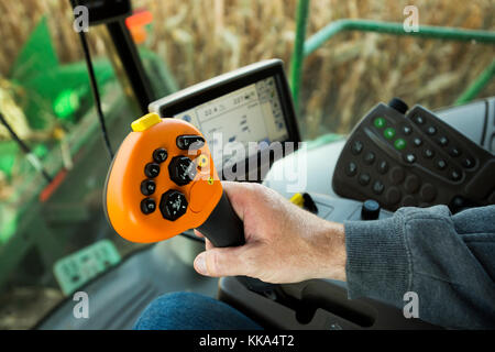 CLOSE UP FARMERS HAND OPERATING CONTROLS IN COMBINE HARVESTER IN UTICA, MINNESOTA. Stock Photo
