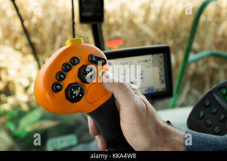 CLOSE UP FARMERS HAND OPERATING CONTROLS IN COMBINE HARVESTER IN UTICA, MINNESOTA. Stock Photo