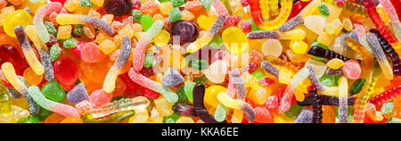 panorama close up a background from colorful sweets of sugar candies and marmalade. assortment candies panoramic view isolated on white background Stock Photo
