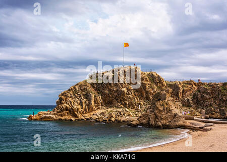National flag of Spain on the rock Sa Palomera Spain, Blanes) Stock Photo