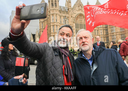 London, UK. 29th Nov, 2017. British Labour party leader Jeremy Corbyn poses for a selfie with a supporter as he attends a rally organized by Unite Union outside Parliament against universal credit changes introduced by the government which will replace other benefits with a single mostly payment. Universal Credit was introduced in 2013 to replace six means-tested benefits and tax credits: income based Jobseeker's Allowance, Housing Benefit, Working Tax Credit, Child Tax Credit, income based Employment and Support Allowance and Income Support Credit: amer ghazzal/Alamy Live News Stock Photo