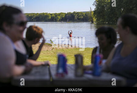 De Soto, Iowa, USA. 6th June, 2017. Haley Gonzales, 10, of Lansing, Iowa looks to her family sitting at a picnic table while playing in the Blackhawk Park swimming area in De Soto, Wisconsin, on Tuesday, June 6, 2017. Credit: Andy Abeyta, Quad-City Times/Quad-City Times/ZUMA Wire/Alamy Live News Stock Photo