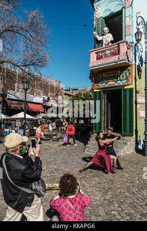 Street tango dancer hamming it up with tourists outside a bar on the corner of El Caminito, La Boca, Buenos Aires, Argentina, South America Stock Photo