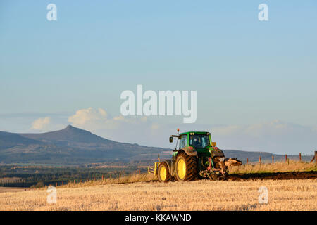 Ploughing a Stubble Field Late on a November Afternoon with Bennachie in the Background Stock Photo