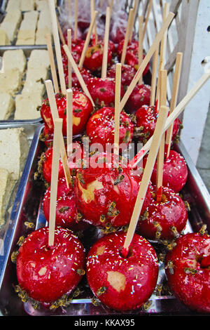 Sweet glazed apples in sugar that attracted a lot of bees. Stock Photo