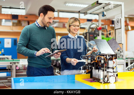 Young attractive students of mechatronics working on project Stock Photo