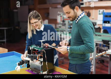 Young attractive students of mechatronics working on project Stock Photo