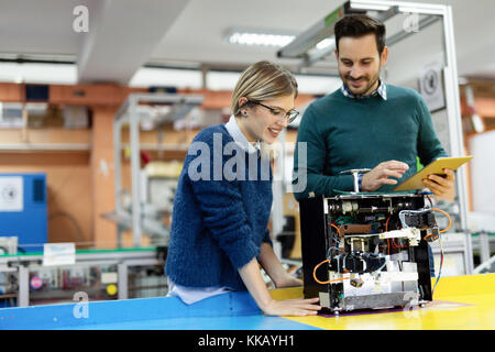 Young attractive students of mechatronics working on project Stock Photo