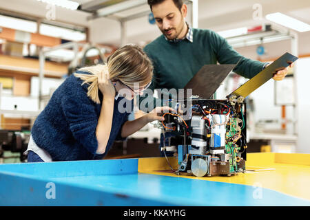 Young attractive students of mechatronics working on project Stock Photo