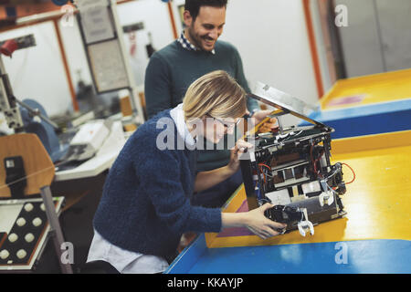 Young attractive students of mechatronics working on project Stock Photo