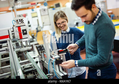 Young attractive students of mechatronics working on project Stock Photo