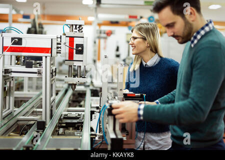 Young attractive students of mechatronics working on project Stock Photo