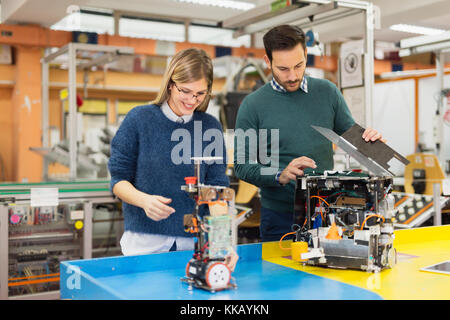 Young attractive students of mechatronics working on project Stock Photo