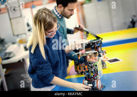 Young attractive students of mechatronics working on project Stock Photo