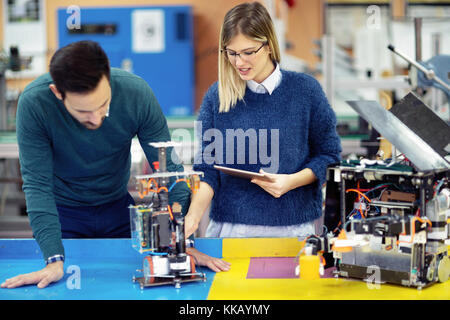 Young attractive students of mechatronics working on project Stock Photo