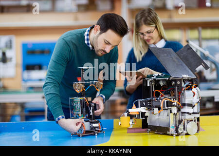 Young attractive students of mechatronics working on project Stock Photo