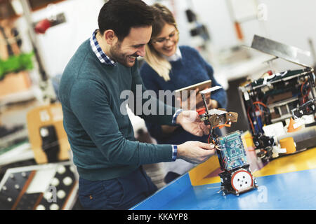 Young attractive students of mechatronics working on project Stock Photo