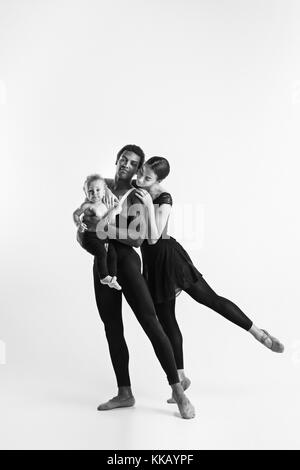 A happy family of ballet dancers on white studio background Stock Photo