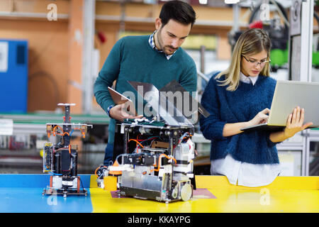 Young attractive students of mechatronics working on project Stock Photo