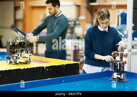 Young attractive students of mechatronics working on project Stock Photo