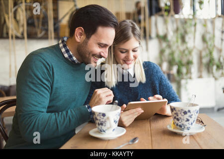 Young attractive couple using tablet in coffee shop Stock Photo