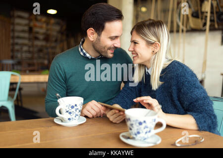 Young attractive couple using tablet in coffee shop Stock Photo