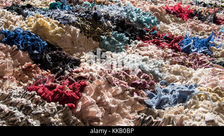 Brightly coloured and heavily textured rag rug in sunlight Stock Photo