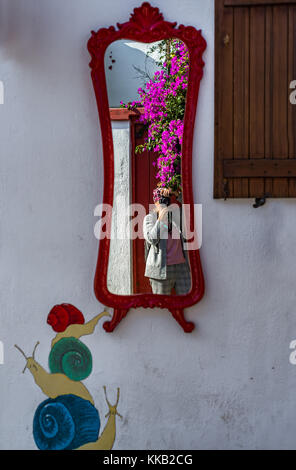 Woman photographer's reflection in old red framed mirror Stock Photo