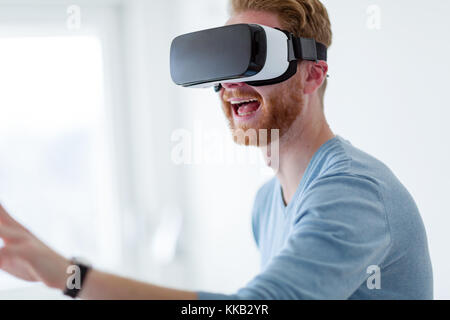 Young handsome man trying virtual reality glasses Stock Photo