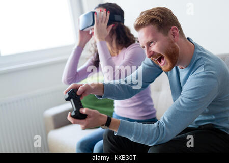 Young couple playing games with virtual reality headset Stock Photo