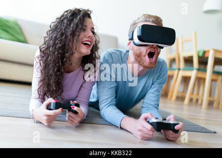 Young couple playing games with virtual reality headset Stock Photo
