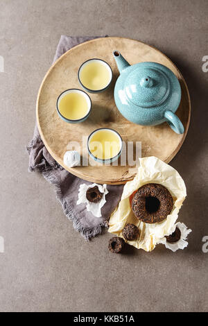 Porcelain chinese cups, steel teaspoon. Black, green, puerh, oolong, tieguanyin, sencha, tea. Gray background Stock Photo