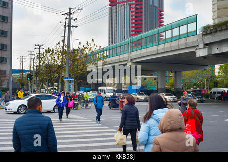 SHANGHAI, CHINA - DEC 23, 2016: People crossing the road in Downtown of Shanghai. Shanghai is one of the most populated cities in the world. Stock Photo