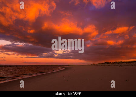 Moments before the storm. Amazing sunrise glow, tinted sky over the beach, in orange color Stock Photo