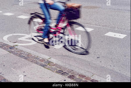 Woman in full speed on a cycle path Stock Photo