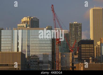Evening light reflected off Chicago skyline showing building construction with red crane Stock Photo