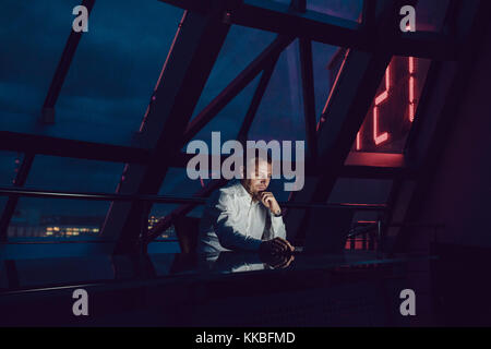 Businessman working on laptop in night office. Stock Photo