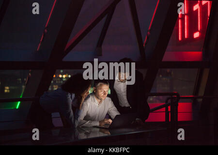 Group of business people working in a night office. Stock Photo