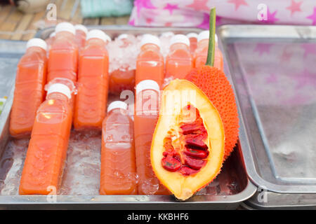 Gac fruit juice, also known as red melon, baby jackfruit, spiny bitter gourd, sweet gourd or cochinchin gourd, Momordica Cochinchinensis, on sale at a Stock Photo