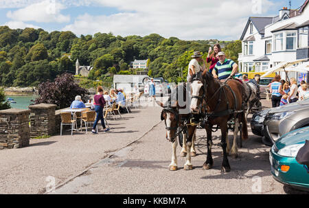 Glandore, County Cork,  Republic of Ireland. Eire. Horses and cart in front of harbour-side restaurants. Stock Photo