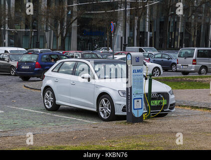 Charging modern electric Audi E-Tron car on the off-street parking from electric vehicle charging station. Eco-car of the future, environmental protec Stock Photo