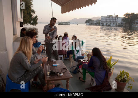 Customers sitting on the lakeside terrace at Jheel's Ginger Coffee Bar & Bakery, by Chandpol, Udaipur, Rajasthan, India
