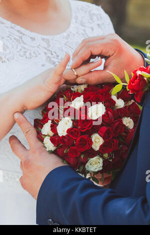 wedding rings and hands of bride and groom. young wedding couple at ceremony. matrimony. man and woman in love. two happy people celebrating becoming family Stock Photo