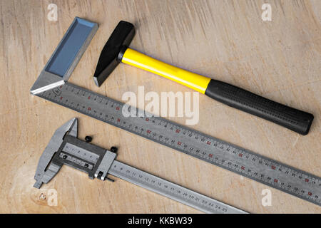 On the table prepared to work tools: hammer, square, ruler, caliper Stock Photo