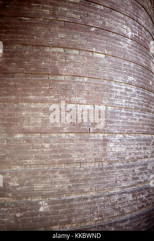 Old curved brick wall with vestiges of white paint in a close up full frame background texture Stock Photo