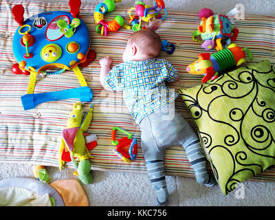 Cute newborn baby sleeping among toys on the floor. Stock Photo