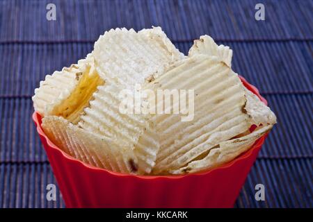fried potato chips in red plastic bowl Stock Photo