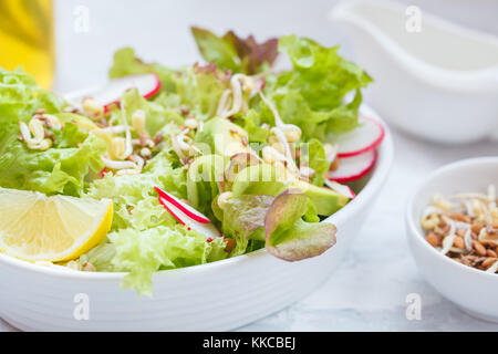 Green vegetable salad with sprouts, beetroot and hummus. Healthy detox vegan food concept. Stock Photo