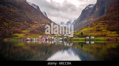 Small homes on the shore of a fjord photographed from a Fjords sightseeing cruise boat leaving Flam in autumn, Norway Stock Photo