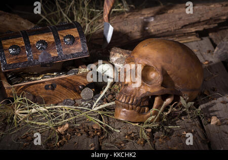 Human skull and treasure chest on weathered wood surface Stock Photo